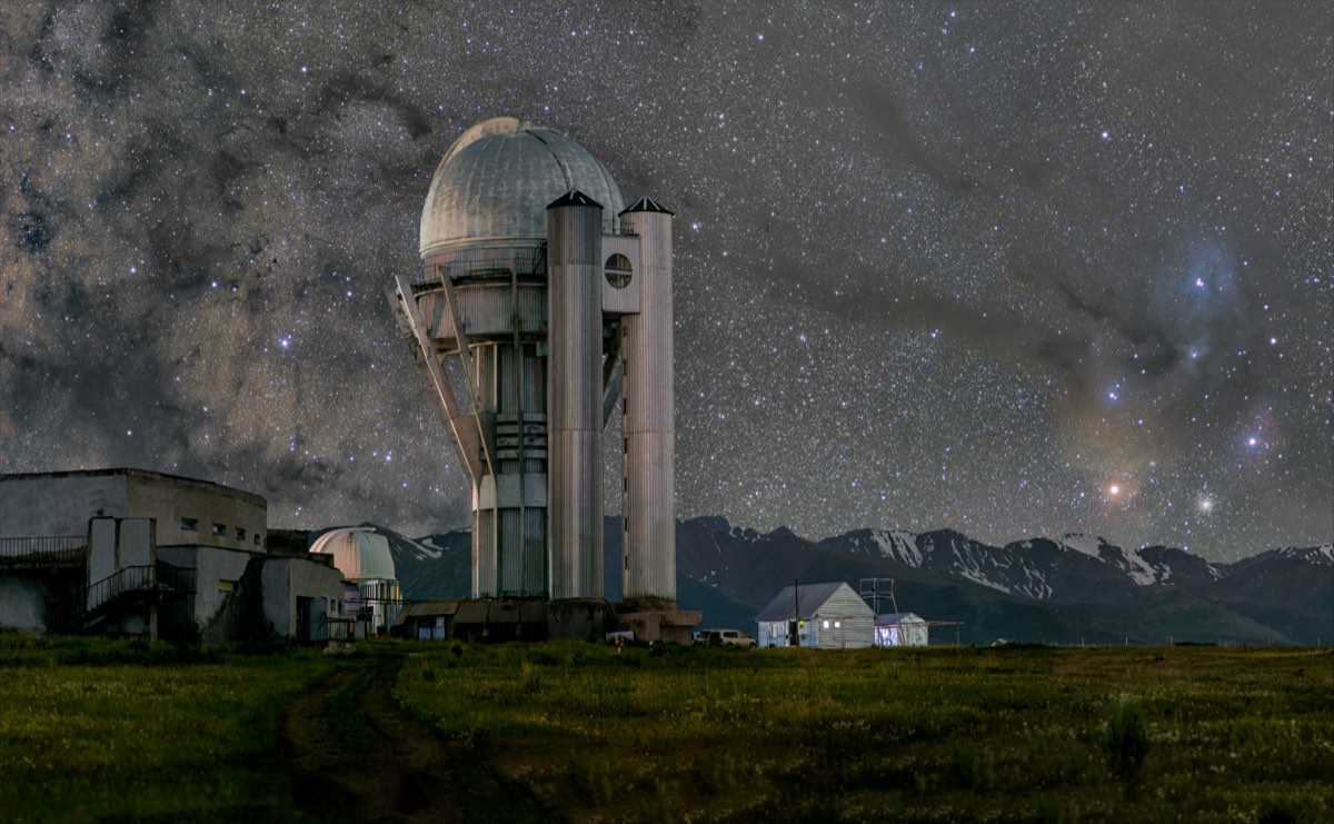 The Milky Way arching over a dark observatory ridge.